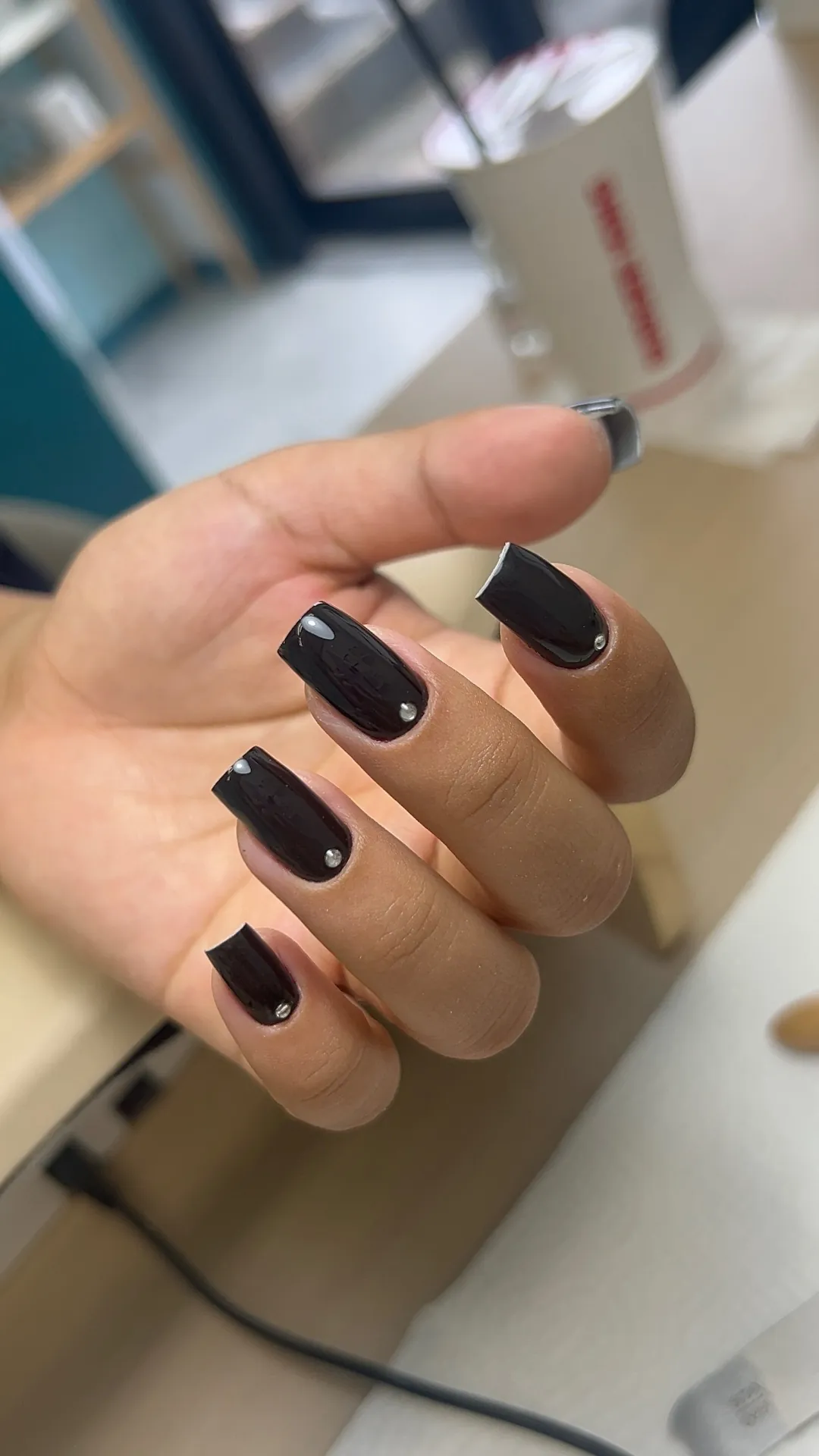Unhas quadradas escuras com detalhes em pedraria