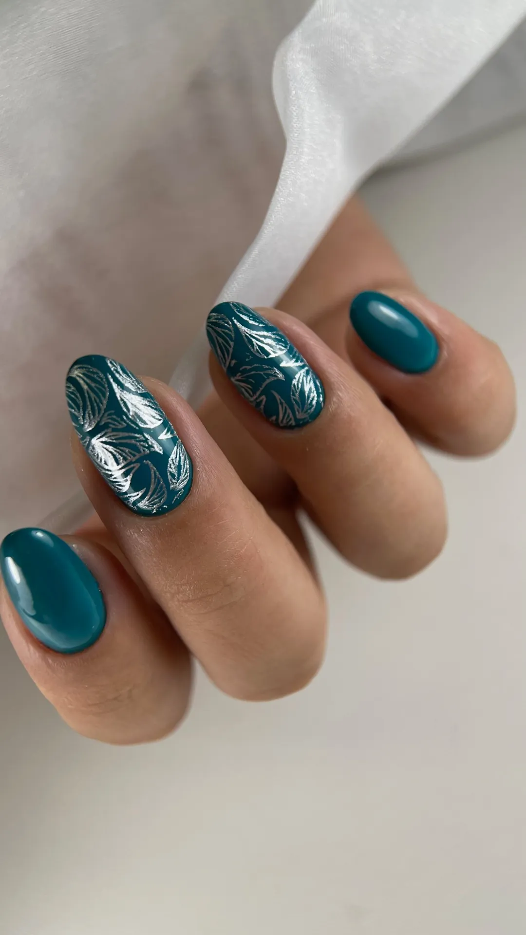 Unhas em gel azul petróleo com nail art prateada
